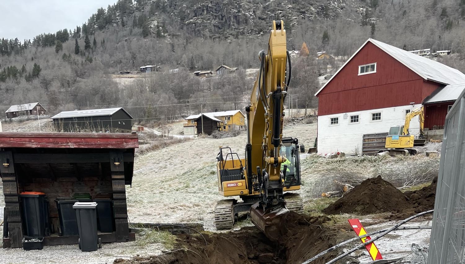Gravemaskin og låve